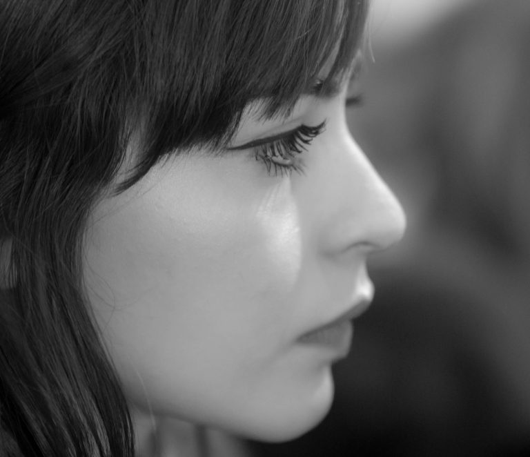 Black and white profile close-up of a woman with a fringe
