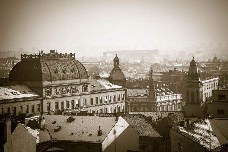 Sepia-toned view over city rooftops and a domed building