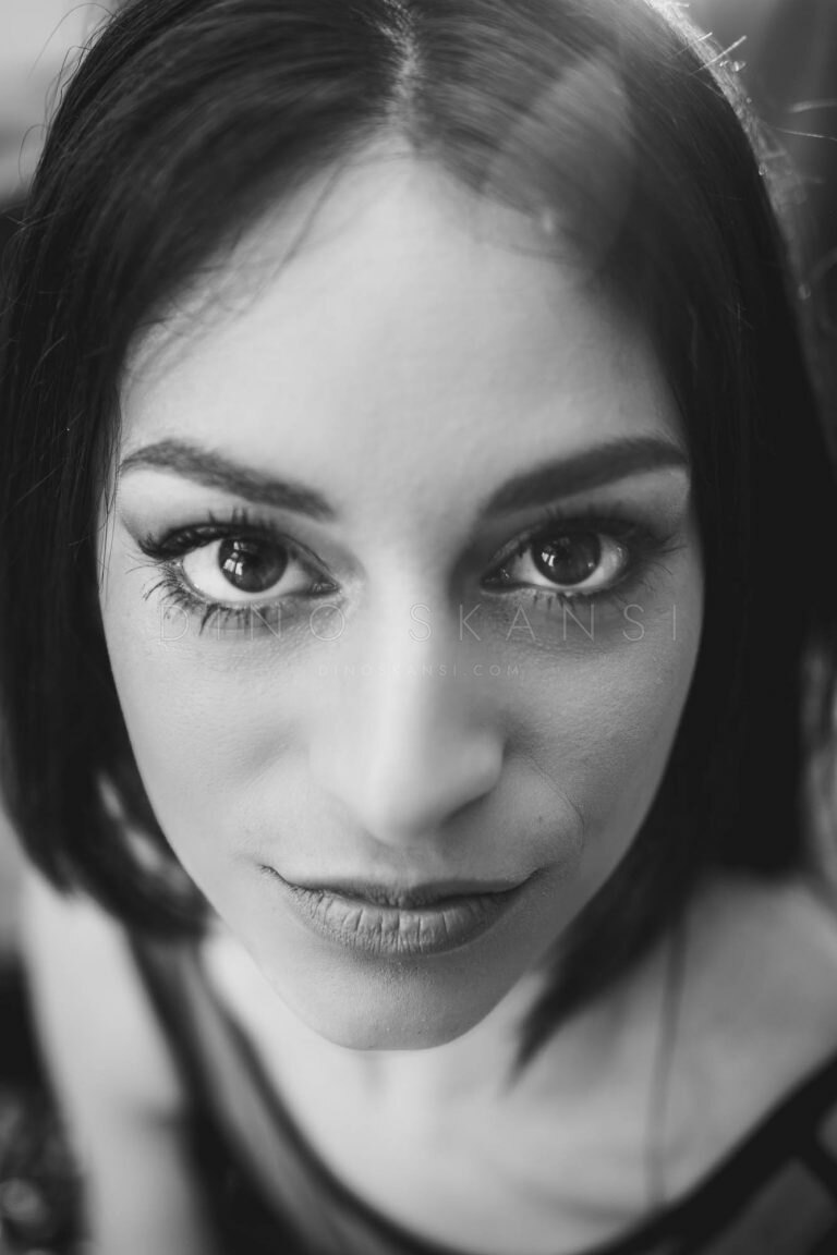 Black and white close-up portrait of a woman with dark hair looking into the camera