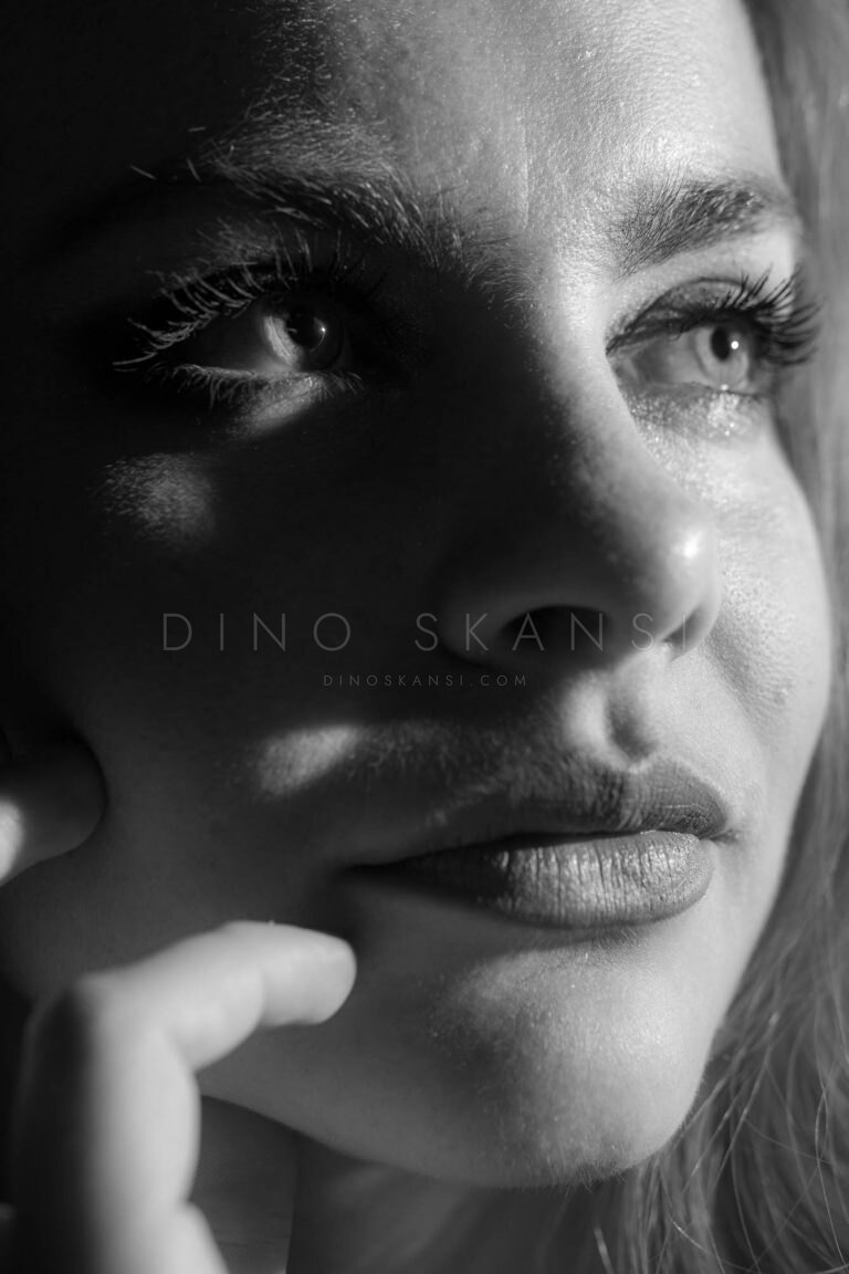 Black and white close-up of a woman's face in dappled shadow