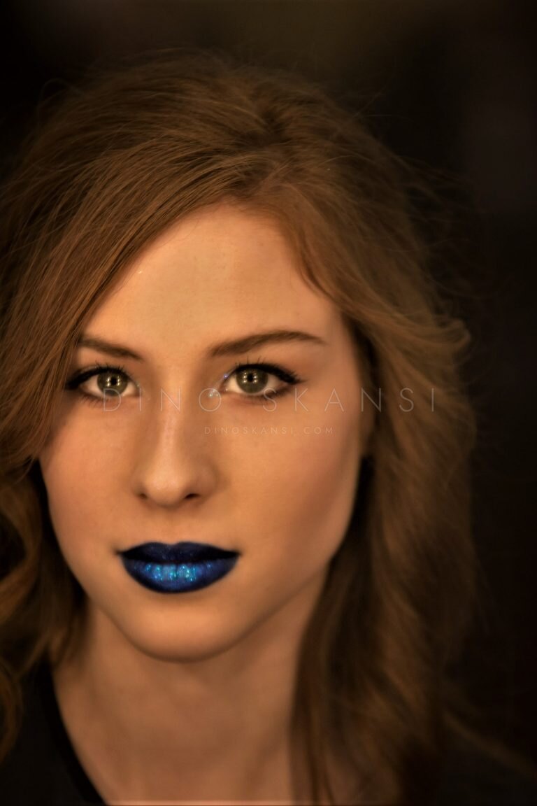 Colour portrait of a woman with auburn hair and blue lipstick