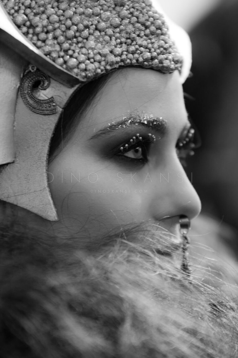 Black and white profile portrait of a woman in an ornate carnival headdress