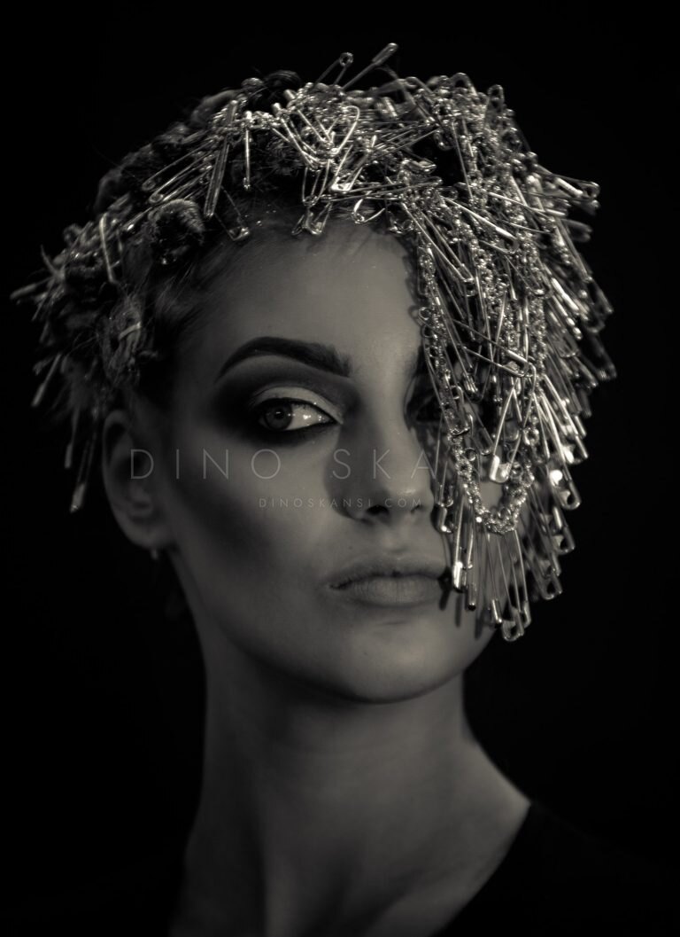 Black and white portrait of a woman wearing a metallic headpiece with dramatic eye make-up
