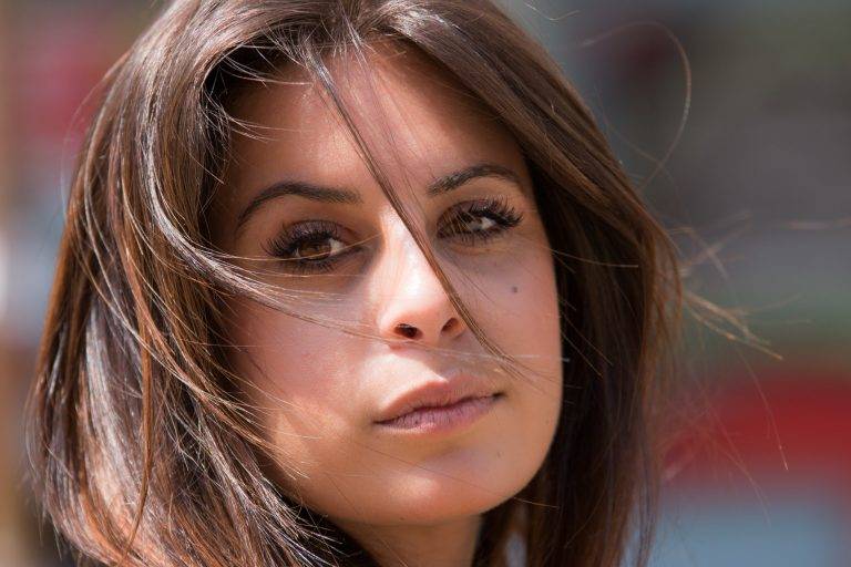 Colour close-up portrait of a woman with windswept brown hair