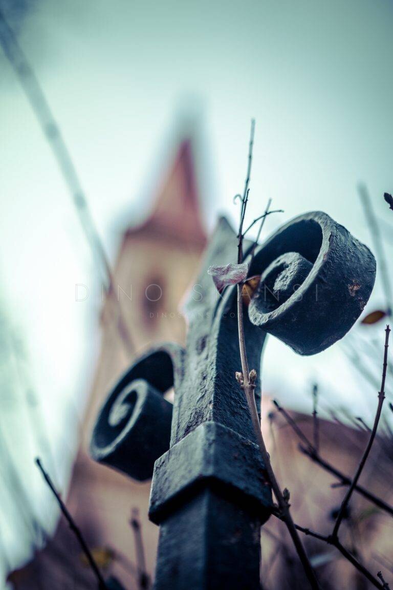Low-angle close-up of wooden wheels with a tower blurred in the background