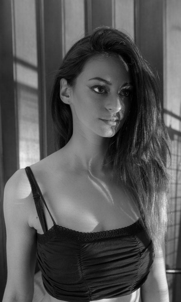 Black and white portrait of a woman with long hair looking over her shoulder