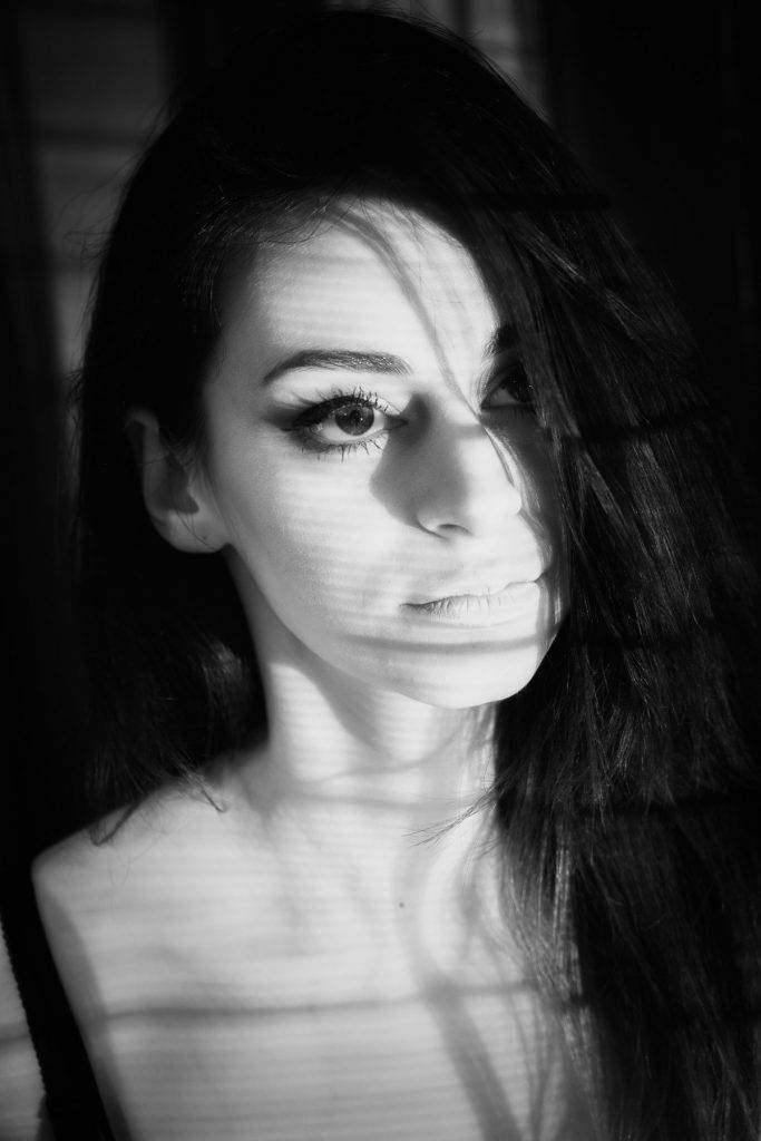 Portrait photography: black and white portrait of a woman with shadows across her face