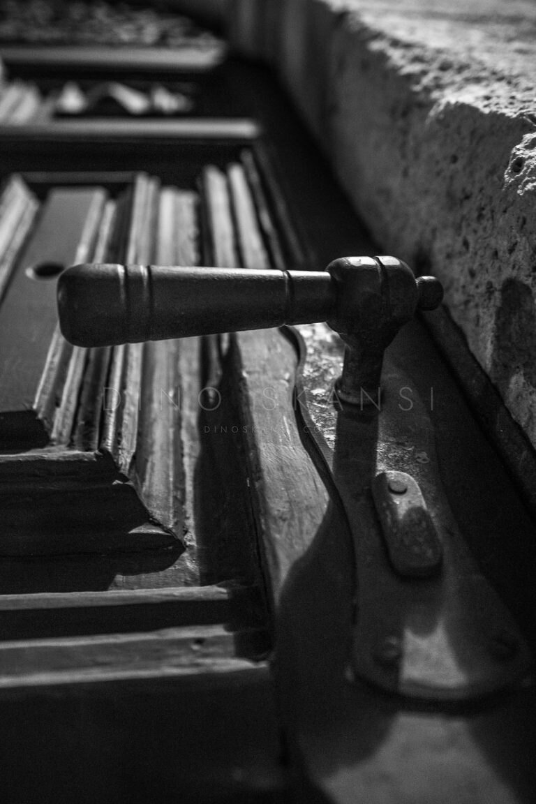 Black and white close-up of a staircase handrail fixture