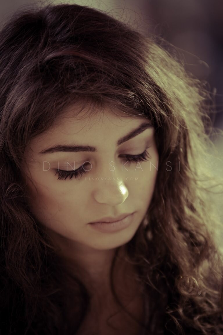 Colour close-up of a woman with curly dark hair looking down