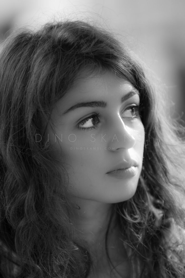 Black and white portrait of a woman with wavy dark hair looking away