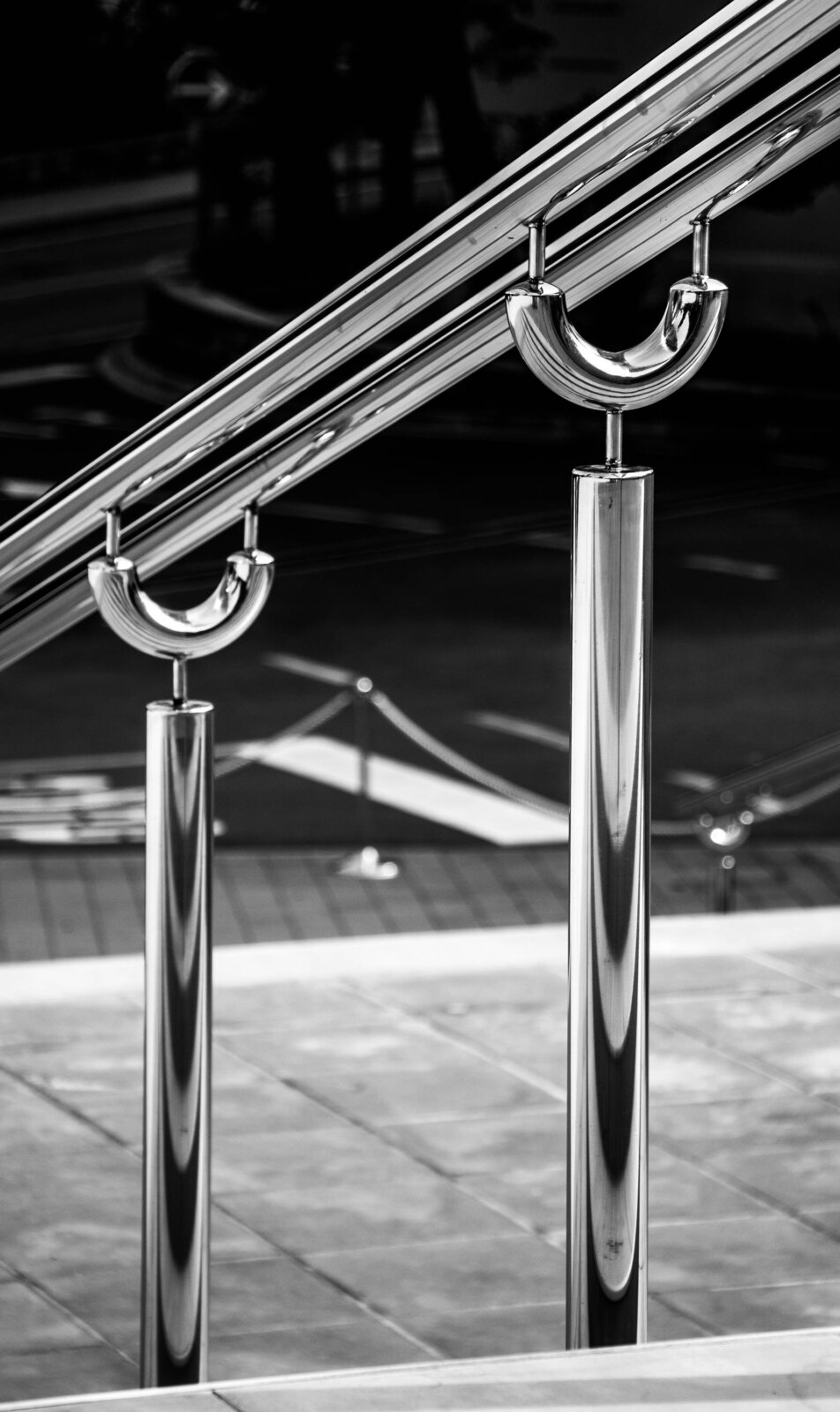 Black and white close-up photograph of a polished chrome handrail