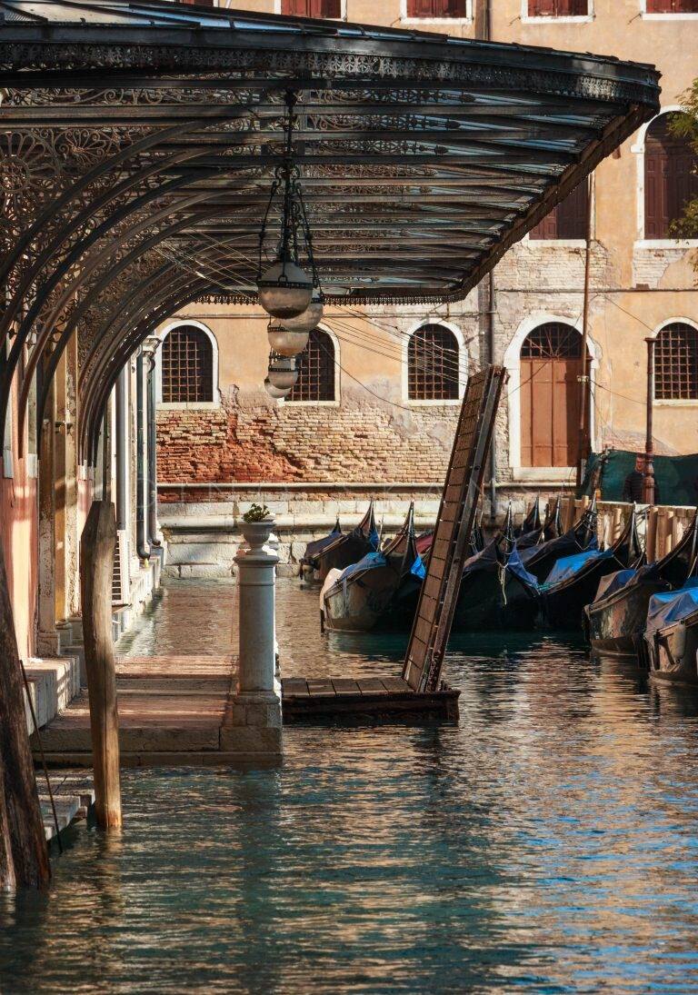 Gondolas moored at a covered canal landing in Venice