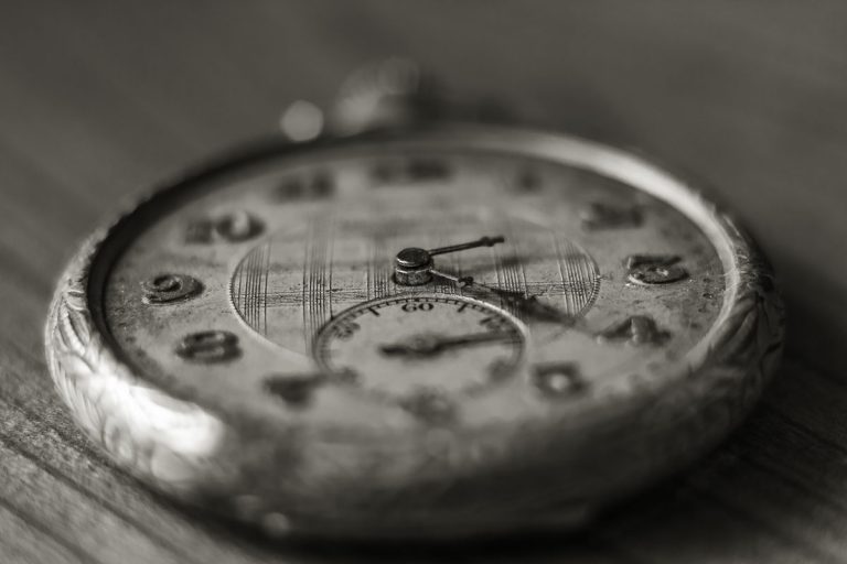 Black and white close-up of an antique pocket watch face