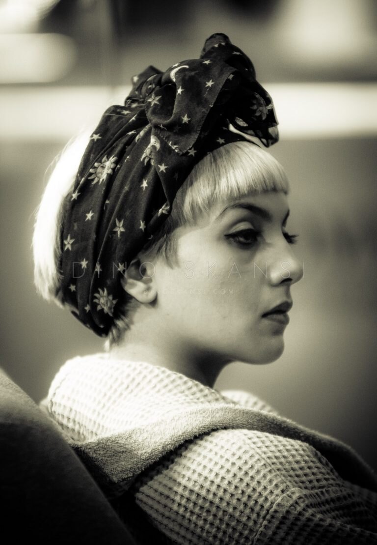 Sepia-toned profile portrait of a woman wearing a patterned headscarf