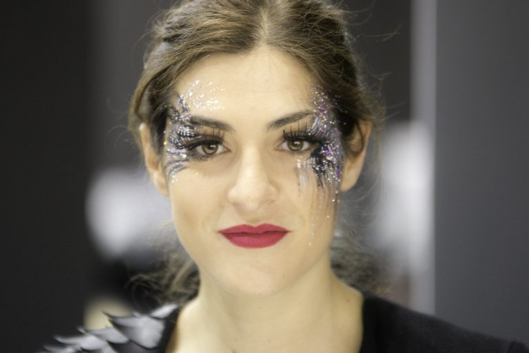 Colour portrait of a smiling woman with glitter make-up around her eyes