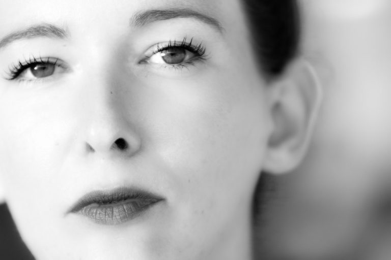 High-key black and white close-up of a woman's eye and lips