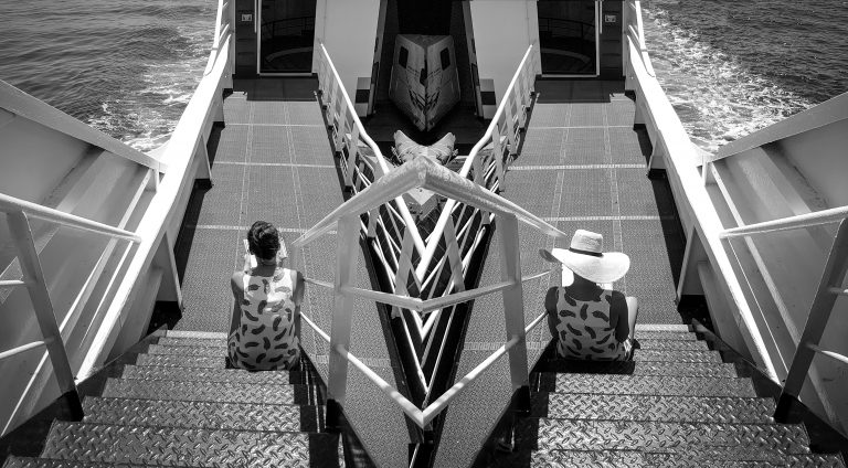 Black and white mirrored composition of statues along a paved walkway