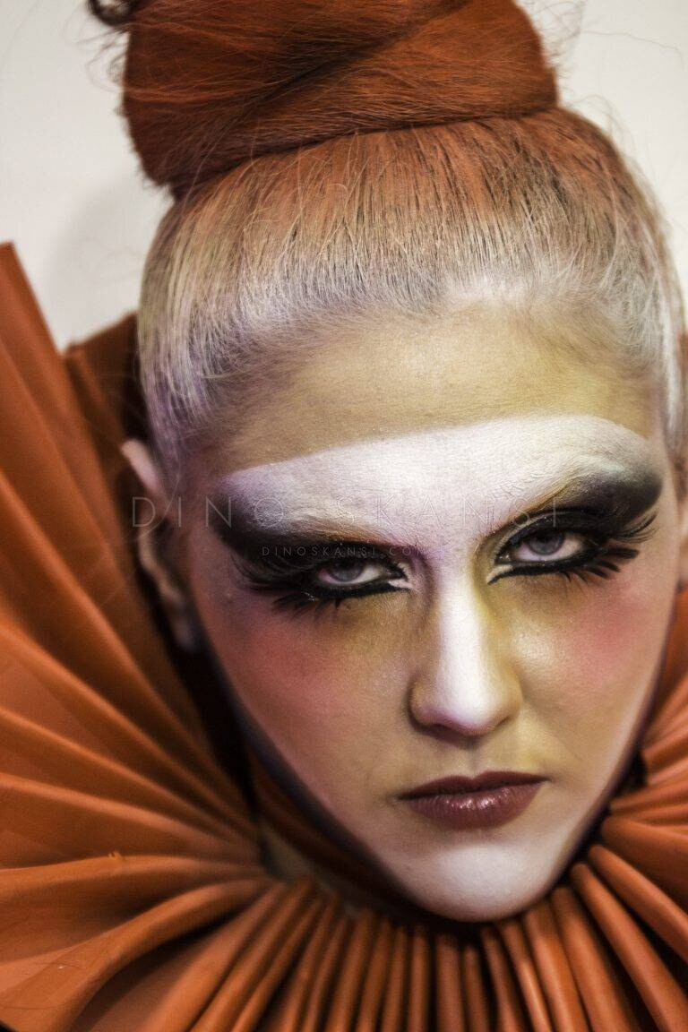 Colour portrait of a woman with theatrical white and gold eye make-up