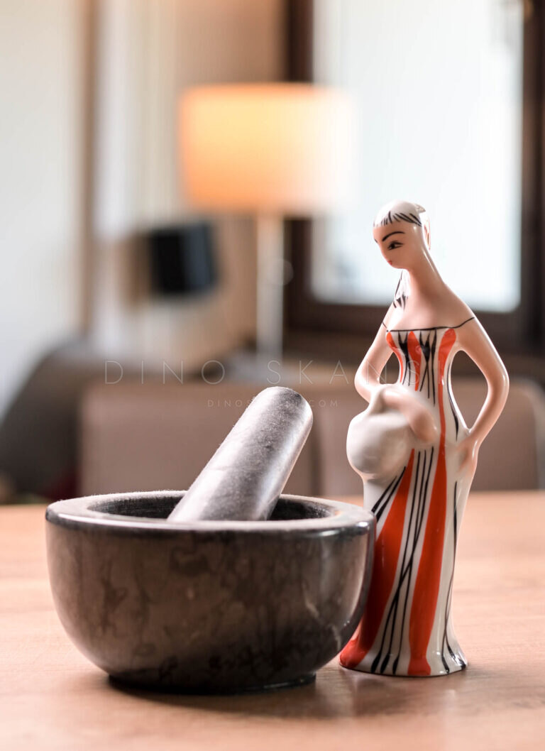 Ceramic figurine of a woman beside a stone mortar and pestle