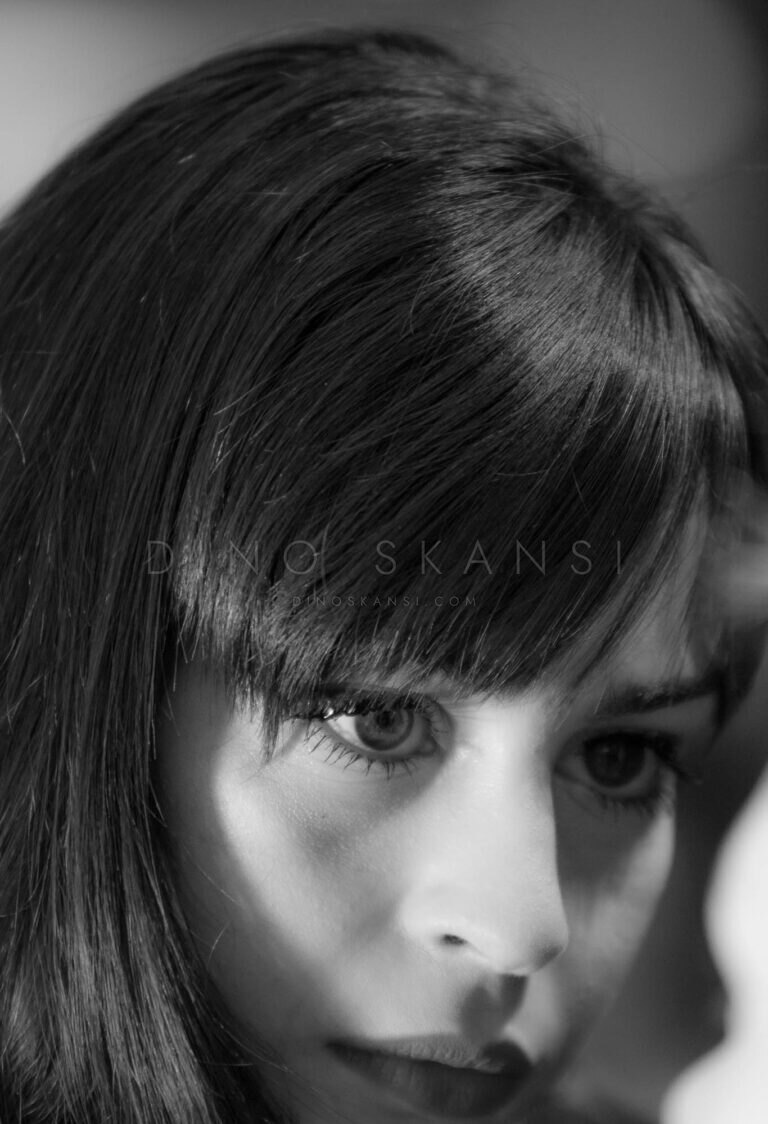Black and white close-up of a woman with a fringe looking at the camera