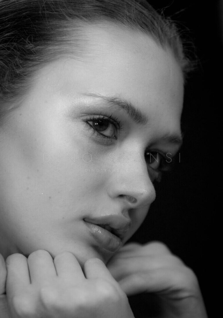 Black and white portrait of a woman resting her chin on her hand