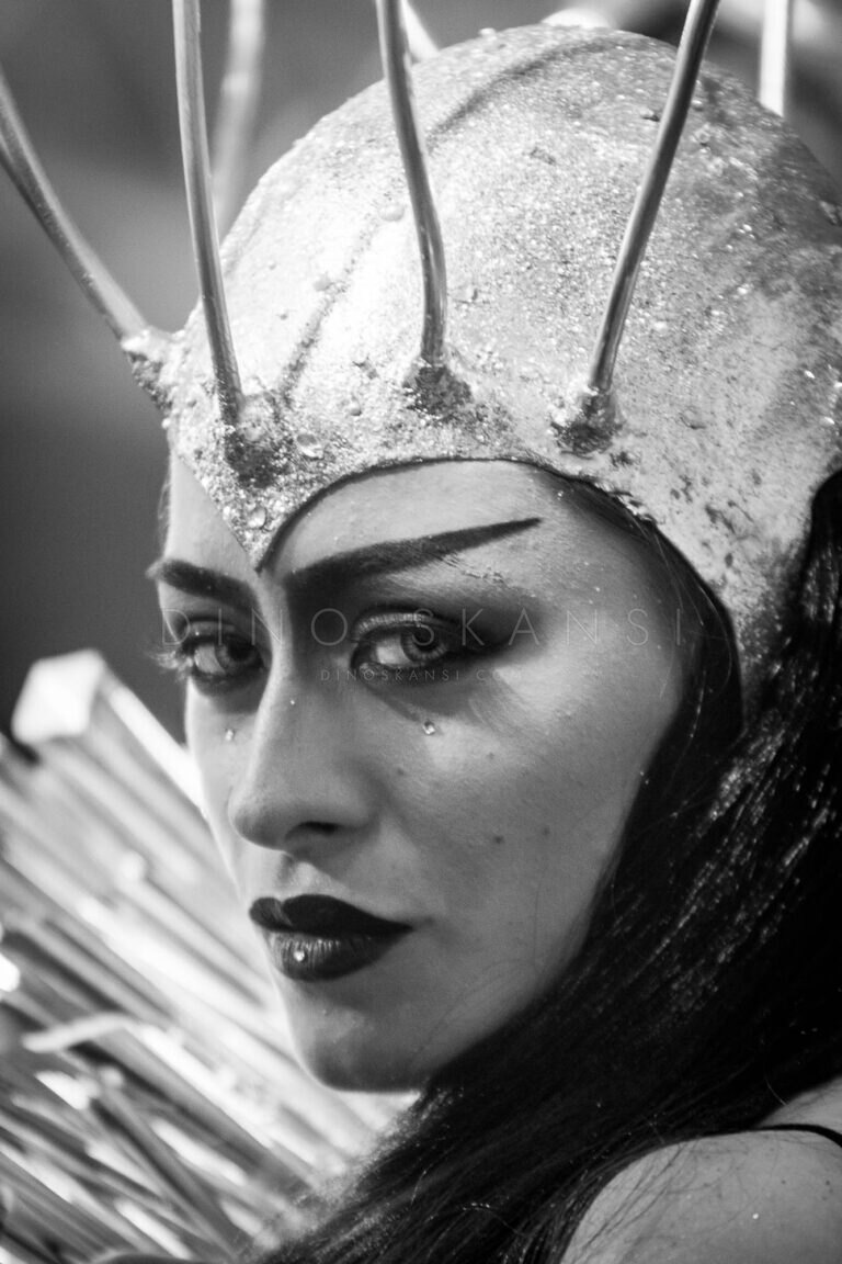 Black and white portrait of a woman in a spiked crown headdress with dramatic make-up
