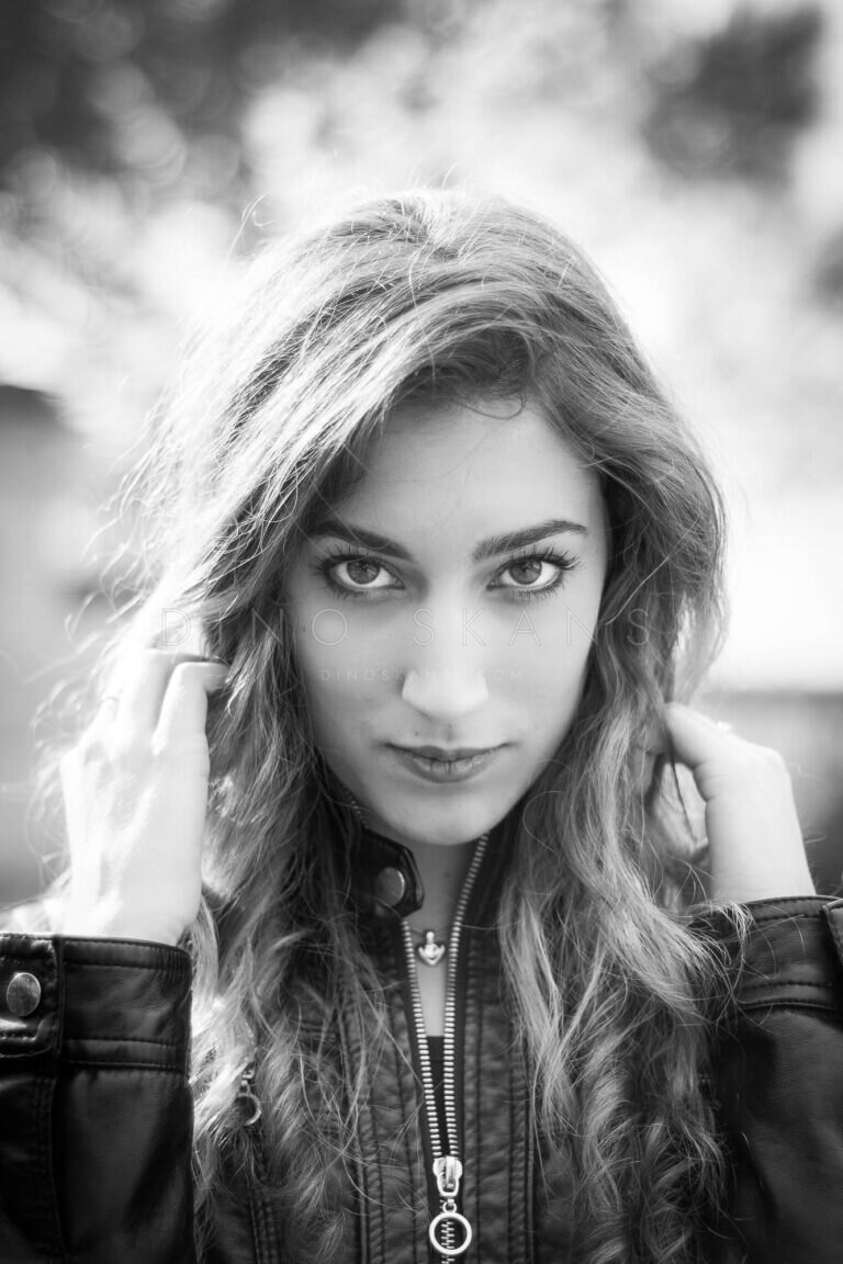 Black and white portrait of a woman with long wavy hair in a leather jacket