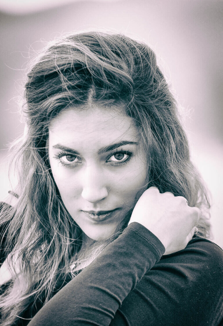 Toned close-up portrait of a woman with her fist under her chin