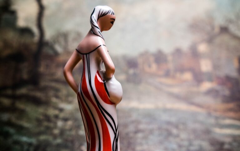 Ceramic figurine of a woman seen from behind against a soft blurred background