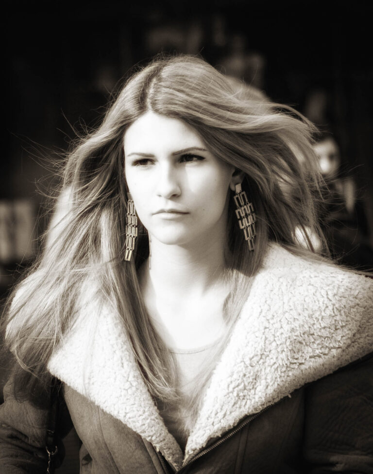 Toned portrait of a woman with long hair in a shearling-collared jacket